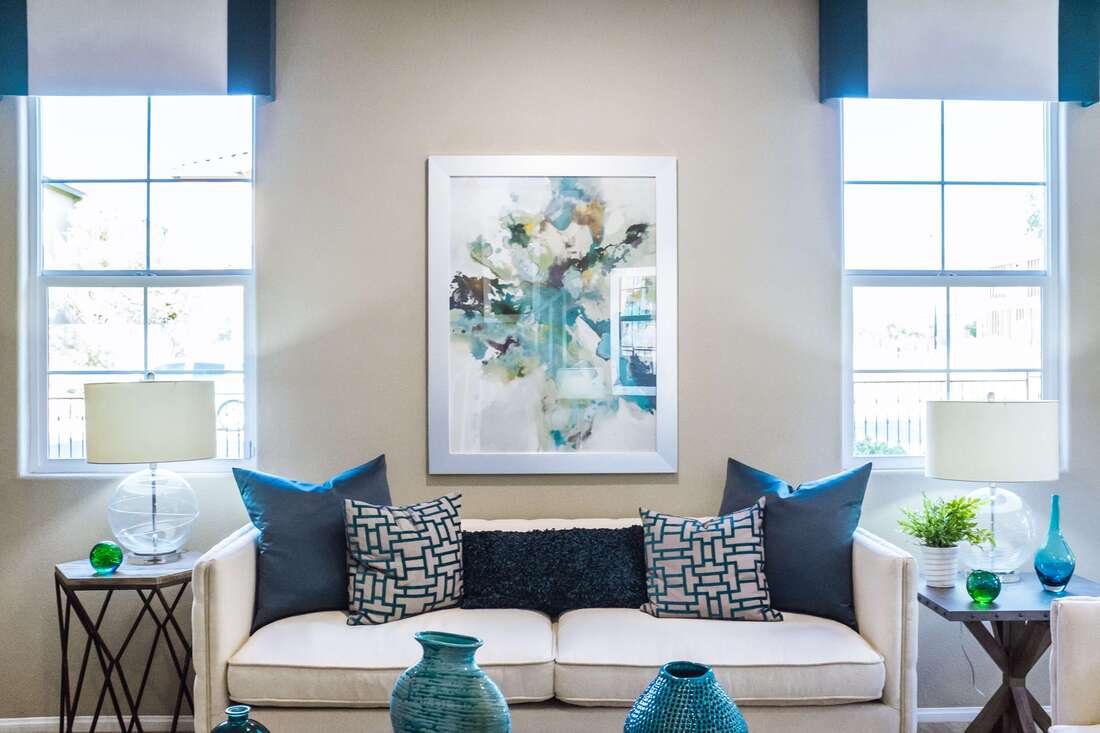 Cozy Home Interior with abstract painting on the wall centered above a white fabric couch
